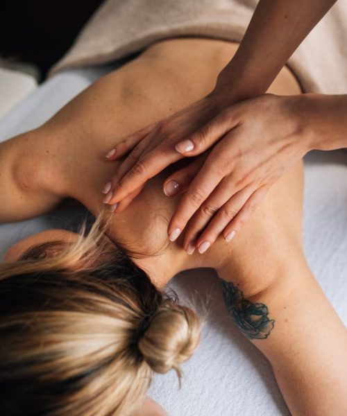 Female receiving a soothing massage in a tranquil spa environment, focusing on wellbeing.